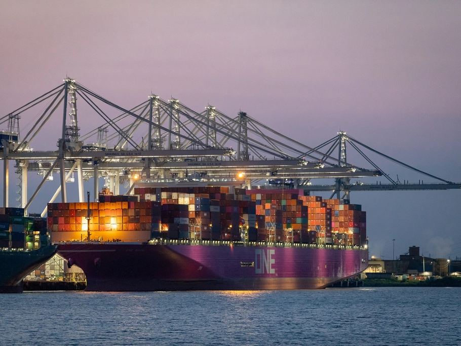 Container terminal at dusk with cranes and a cargo ship